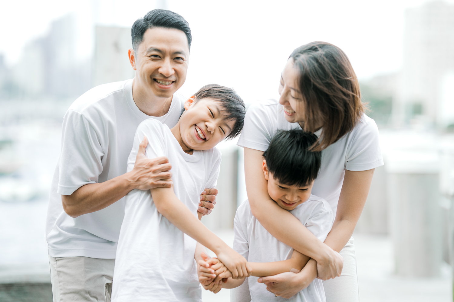 A family of boys with their mum and dad playing by the bay