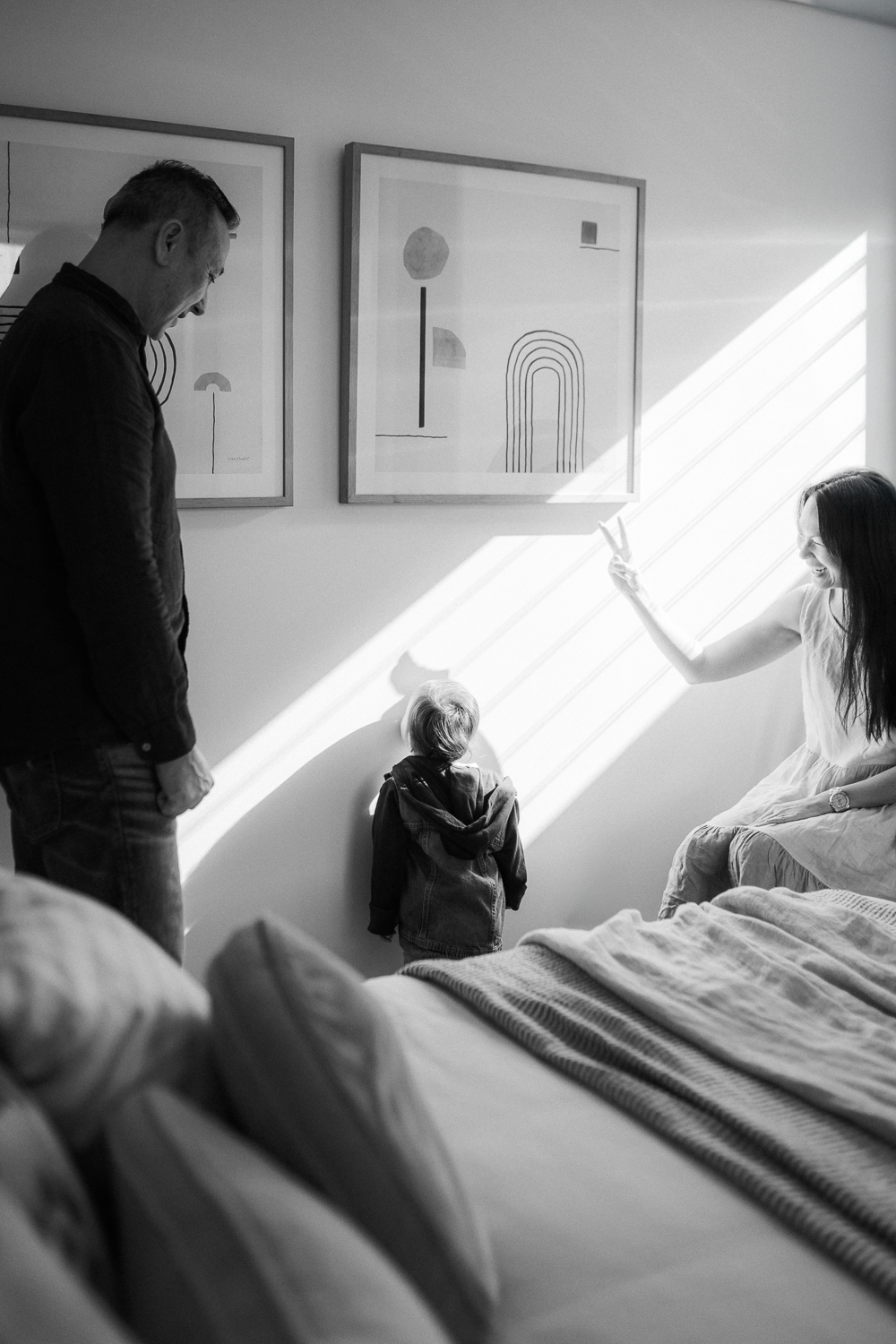 Mum and dad playing shadow puppet with toddler at home in Sydney inner west