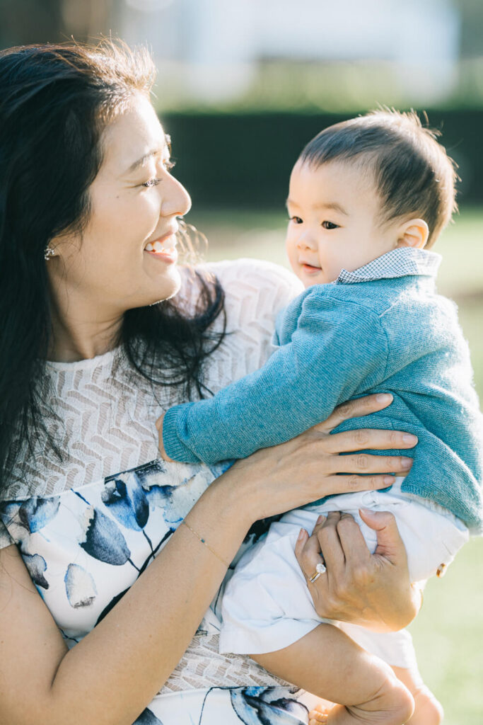 Mum holding baby close during a walk at the park