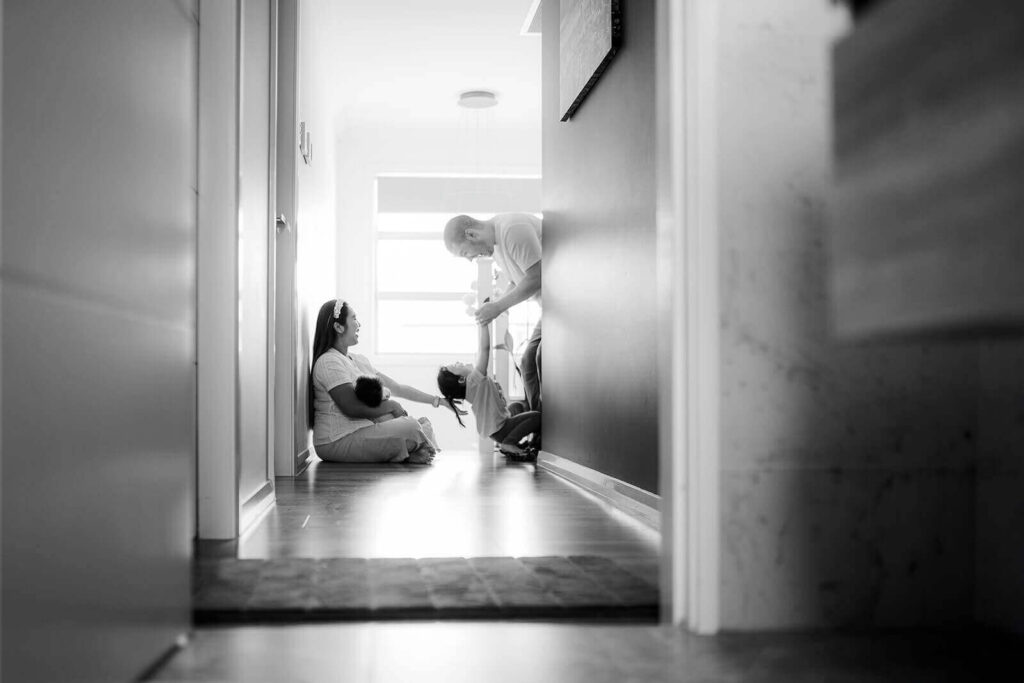 Candid in-home newborn photo showing the beautiful chaos of family life in Sydney