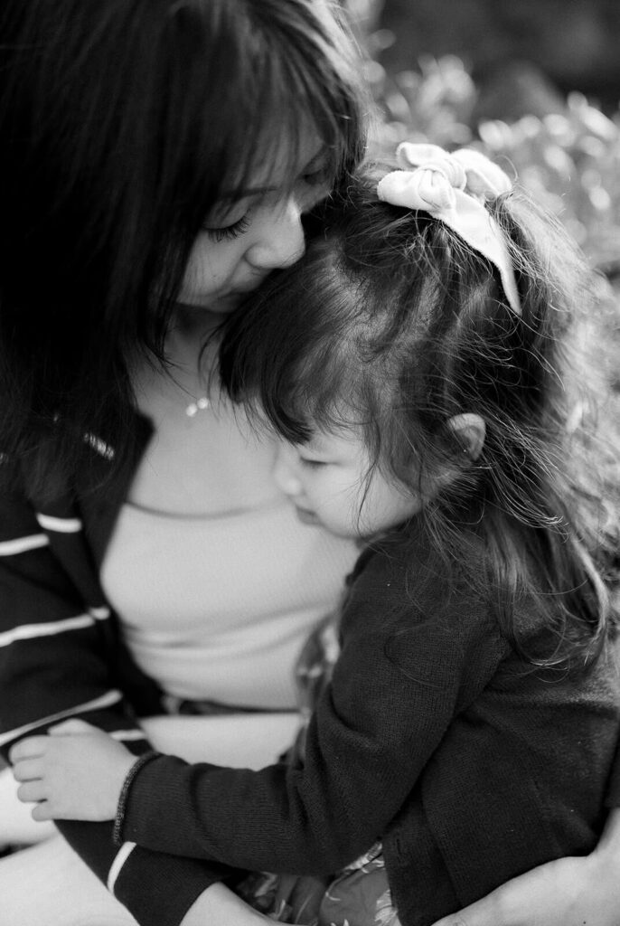 Mother hugging young child during outdoor family photography session, capturing a warm emotional connection
