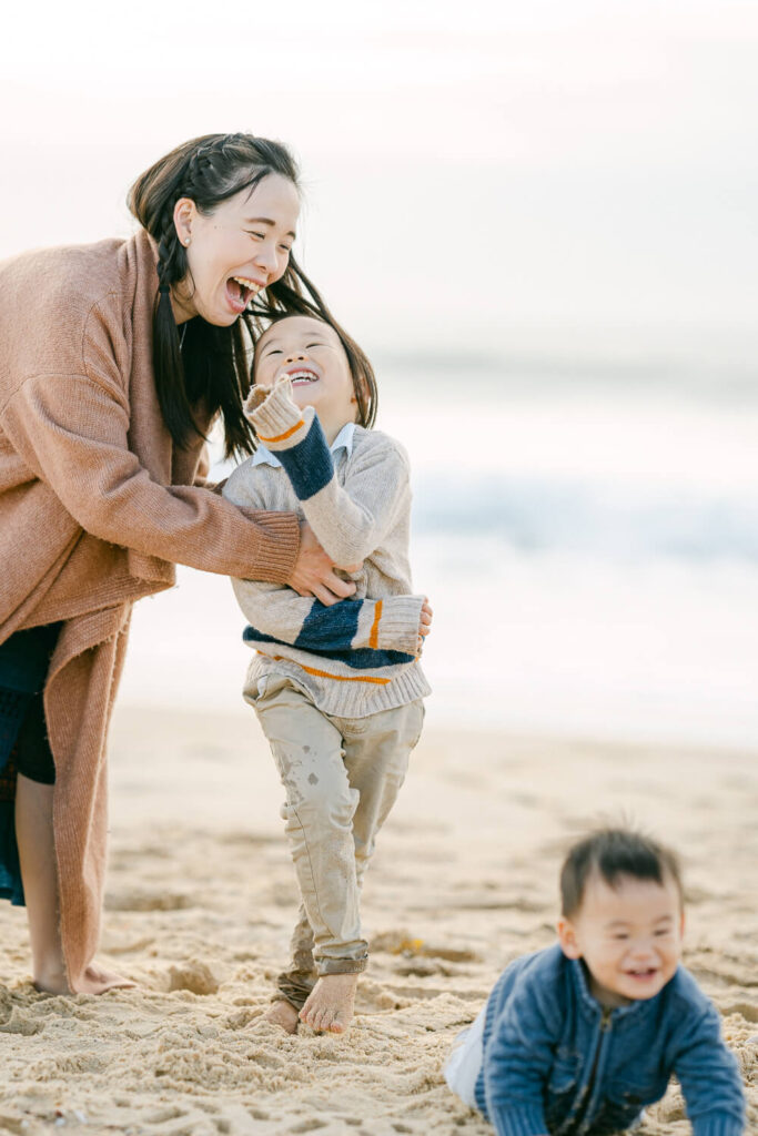 candid moment of mum playing with young kids in laughing in the middle of chaos