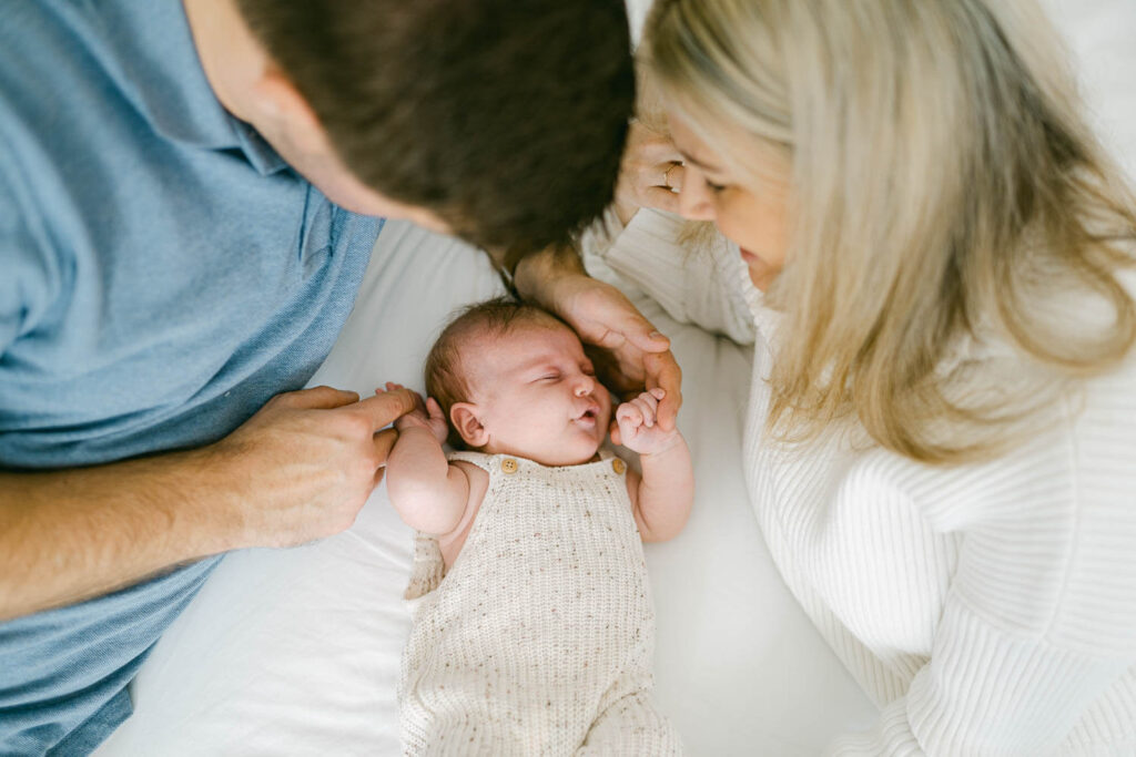 Parents holding newborn in nursery during natural in-home newborn photography session in Sydney
