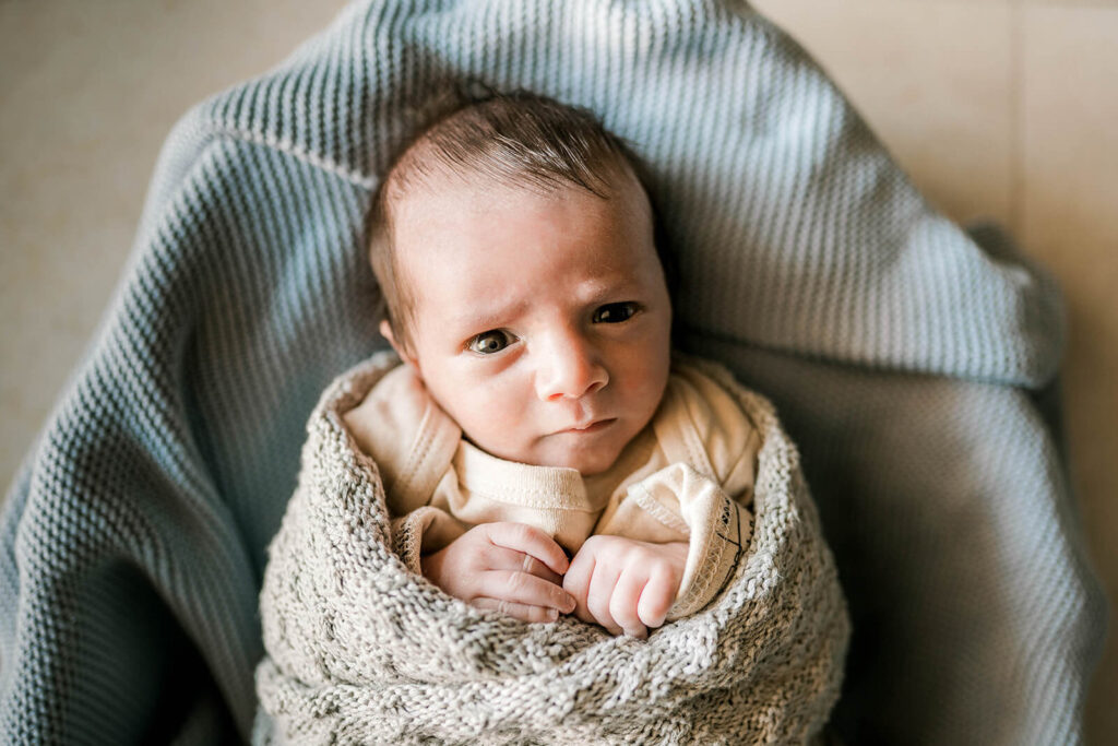 Close up of newborn baby awake and swaddled