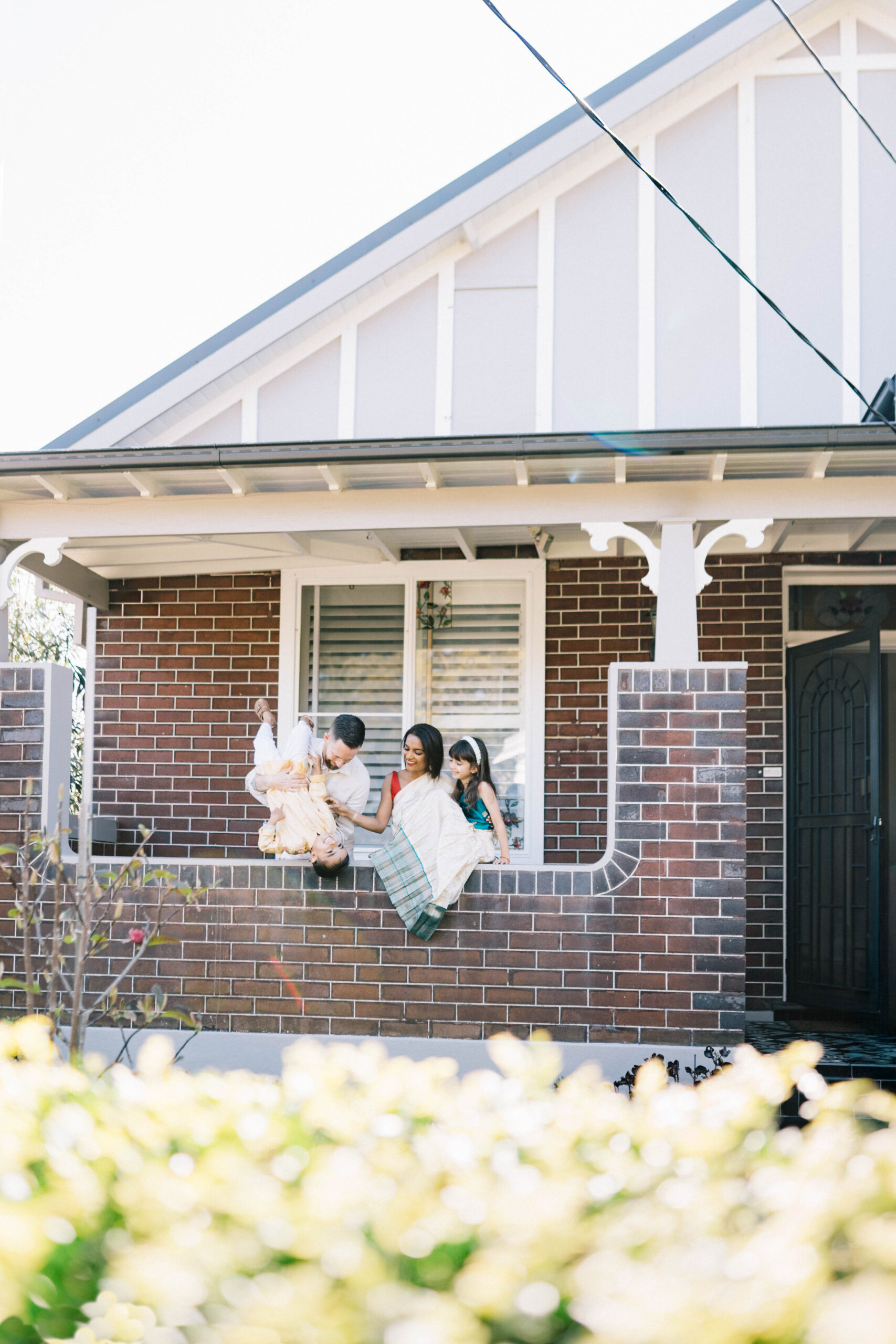 Family of four at playing outside their home on sunny morning