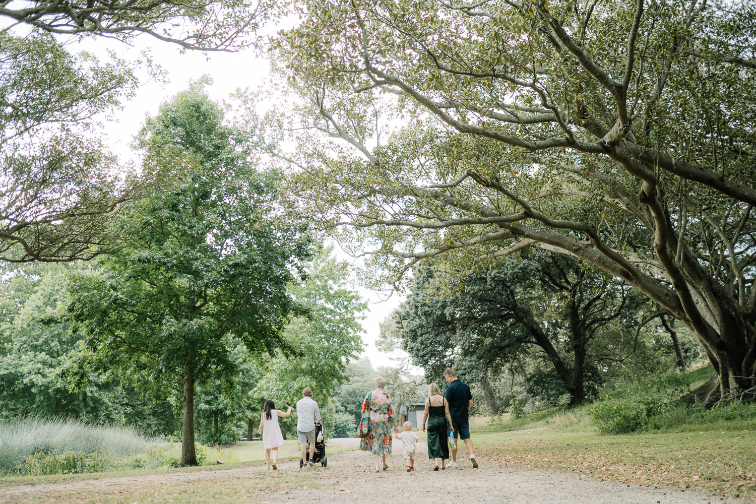Grandmother surrounded by her sons and grandchildren during a relaxed family photo session at the park