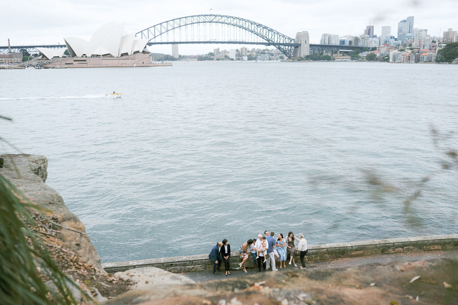 three generation big extended family photo against Sydney Harbour Bridge in cloudy afternoon